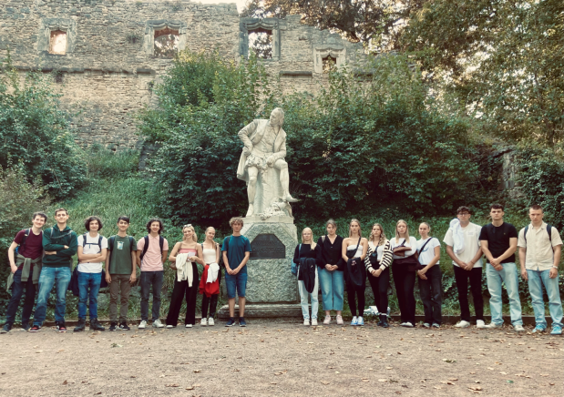 Schüler und Schülerinnen der Jahrgangsstufe 12 neben der Shakespeare-Statue in Weimar  